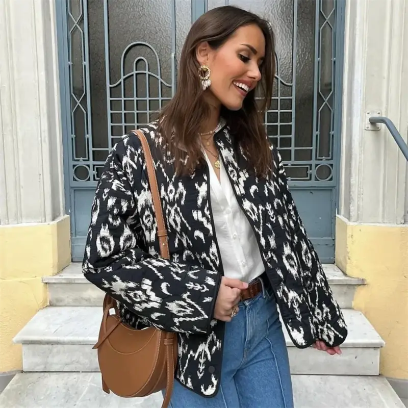 Black and white patterned versatile printed jacket paired with blue jeans and leather bag