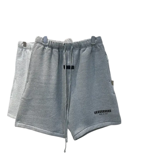 Light gray hip hop jogger shorts with black drawstring on rack