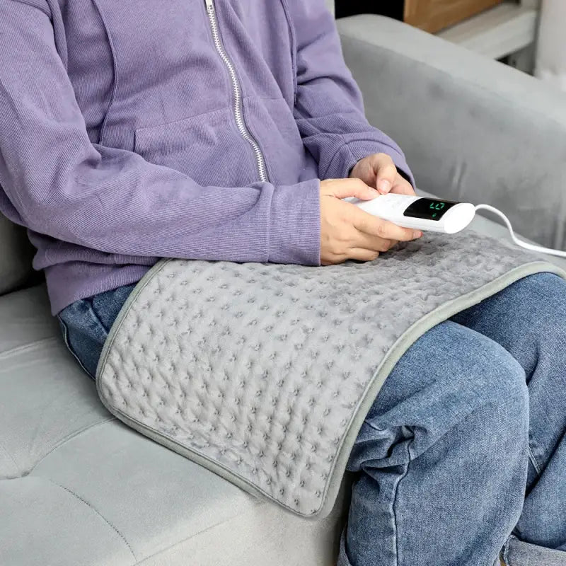 Dark grey electric heating blanket with textured cover and controller for sofa bed