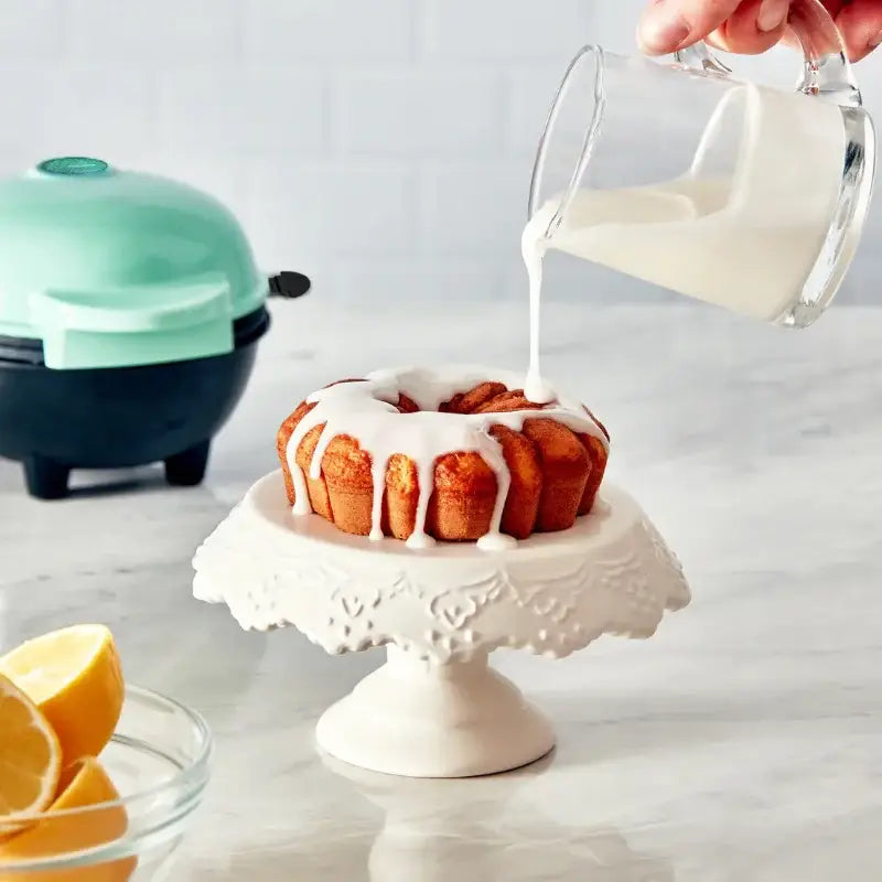 Glazed bundt cake on a decorative stand with icing, perfect for Non-Stick Waffles Kitchen
