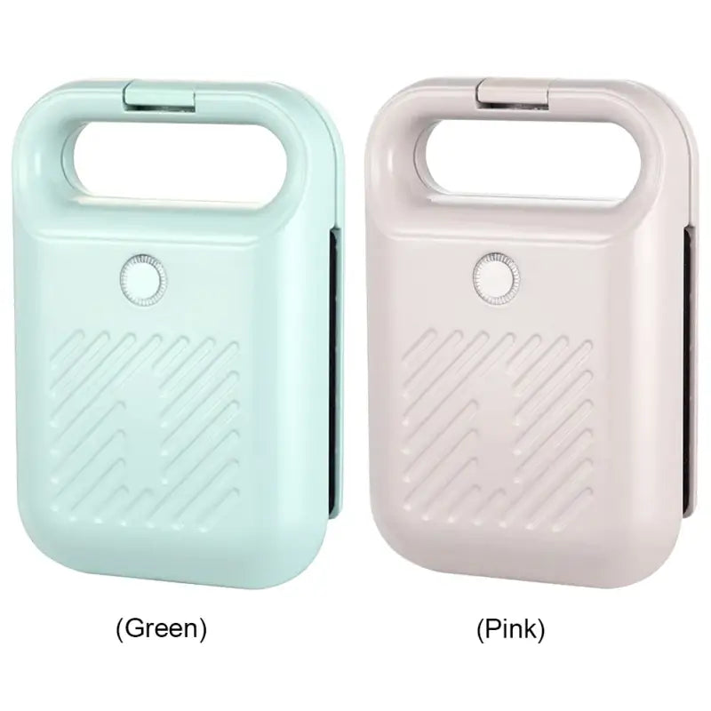 Two portable hand warmers in mint green and light pink near a Panini Press