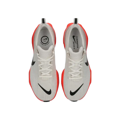 White and orange Nike running shoe with black swoosh and cushioned support